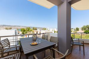 een eettafel op het balkon van een huis bij Ethereal Apartments Chania in Souda