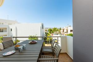 a table on a balcony with a view of a street at Ethereal Apartments Chania in Souda