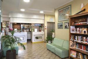 biblioteca con divano verde e libreria di Hotel Marselli a Rimini