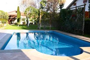 a swimming pool with blue water in a yard at La Villetta Suite in Ciampino