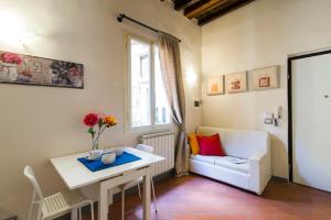 een woonkamer met een witte bank en een tafel bij Ponte Vecchio Central Flats in Florence