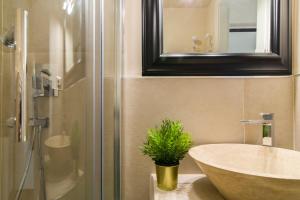 a bathroom with a sink and a mirror and a plant at Ponte Vecchio Central Flats in Florence