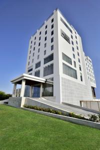 a large white building with a lawn in front of it at Country Inn & Suites by Radisson Kota in Kota