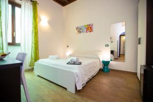 biała sypialnia z łóżkiem i lustrem w obiekcie POP Art B&B w Rzymie