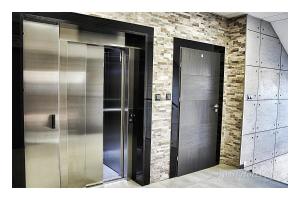 Dos ascensores en una habitación con una pared de ladrillo en Apartamenty Piła en Piła