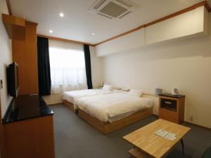 a hotel room with a bed and a television at Awajishima Hotel Lodge GREEN COZY in Minamiawaji