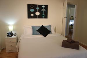 a bedroom with a large white bed with blue pillows at My Port Lincoln Place in Port Lincoln