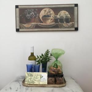 a tray with a bottle of wine and a plant at Villa Lemonia - Guest House in Aroniadika