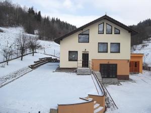 uma casa com neve em frente em Windstille em Oščadnica