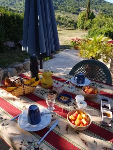 a table with plates of food and bowls of fruit at Chambre d'hôte insolite in Séderon