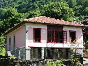 Belmonte de MirandaにあるCasa Rural La Lleronaの赤窓付き小さなピンクの家