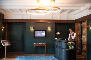 TV a/nebo společenská místnost v ubytování Le Manoir Hôtel