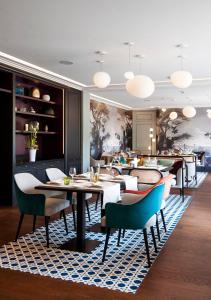 un restaurant avec des tables et des chaises sur un tapis dans l'établissement Le Manoir Hôtel, à Le Touquet-Paris-Plage