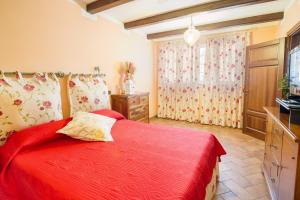 a bedroom with a red bed with a red blanket at Villa Lisa in Diano Marina