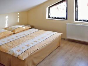 um quarto com uma cama e duas janelas em Windstille em Oščadnica