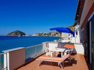 a balcony with a table and an umbrella at Hotel La Gondola in Ischia