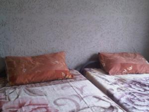 two beds with orange pillows sitting next to each other at Sleek Hostel in Johannesburg