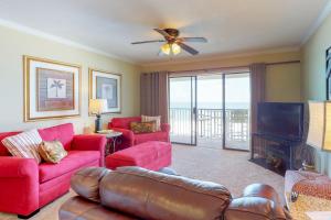 a living room with red couches and a television at The Whispering Seas in Panama City Beach