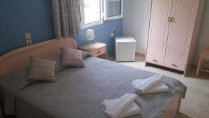a bedroom with a bed with two towels on it at Ifigenia Hotel in Skiathos Town