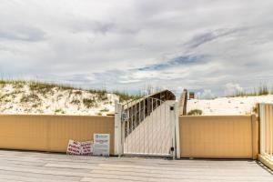 a gate to a beach with a sand dune at Romar Beach Condos in Gulf Shores