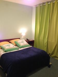 een slaapkamer met een bed en een groen gordijn bij Bel Air in Marville