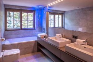 
a bathroom with a tub, sink and toilet at Mountain Spa Residences in Sankt Anton am Arlberg
