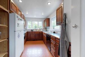 a kitchen with wooden cabinets and a white refrigerator at Big Blue in Neskowin