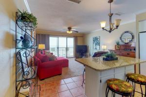 a kitchen and living room with a red couch at The Whispering Seas in Panama City Beach