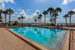 uma grande piscina com palmeiras e o oceano em Riverside Club em Marco Island
