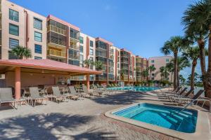 a resort with a pool and chairs and palm trees at Riverside Club in Marco Island