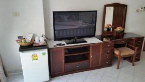 a television on a wooden entertainment center with a refrigerator at Orchid Residence in Patong Beach
