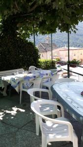 un grupo de mesas, sillas y árboles blancos en Trattoria Bar Pace en Re
