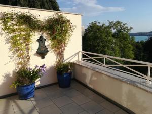 a balcony with two potted plants on a wall at Ferienwohnung Seeblick in Überlingen