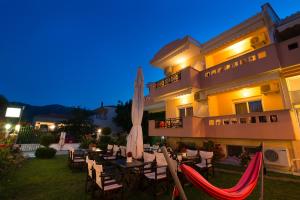 a hotel with a patio with chairs and a umbrella at Nikolas Studios in Chrysi Ammoudia