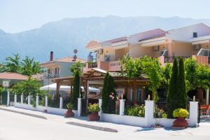 a row of houses with trees and a fence at Nikolas Studios in Chrysi Ammoudia