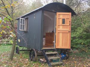 una casita negra en un carro con una puerta en The Hut en Ventnor