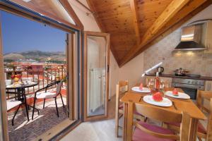 a kitchen with a table and chairs and a balcony at Poseidon Sea View Apartment in Argostoli
