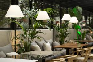 a restaurant with tables and chairs and potted plants at ICON Embassy in Madrid +39 photos