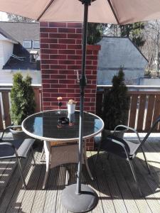 a table and chairs on a patio with an umbrella at Jurmala's Centre Apartments in Jūrmala