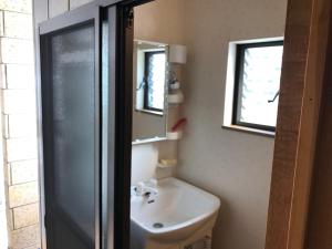 a bathroom with a sink and a mirror at Guest House Hennka Kyoto in Kyoto