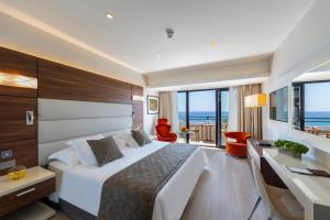 a hotel room with a large bed and a desk at Amathus Beach Hotel Limassol in Limassol