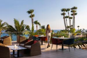 a woman standing on a deck at a resort at Amathus Beach Hotel Limassol in Limassol