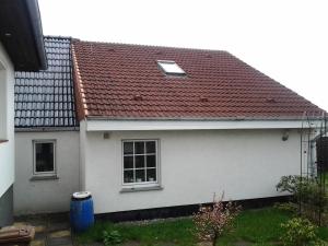 a white house with a red roof at FeWo in Wismar in Wismar