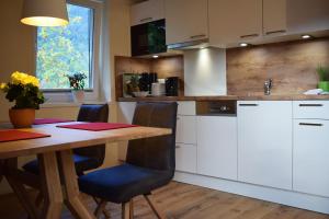 a kitchen with a wooden table and a table and chairs at Haus Partale in Oberstdorf