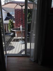 una puerta abierta a un patio con mesa y sombrilla en Jurmala's Centre Apartments en Jūrmala