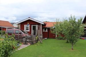 une maison rouge avec une voiture garée devant elle dans l'établissement Utmelandsvägen 26, à Mora