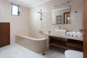 a bathroom with a tub and a sink and a mirror at Villa Soumela in Nikiana +29 photos