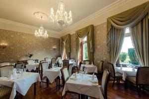a dining room with tables and chairs and a chandelier at Cahernane House Hotel in Killarney
