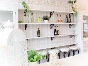 una cocina con estanterías blancas con botellas y taburetes en Hotel Caretta, en Tatsugo
