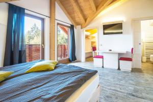 a bedroom with a bed and a large window at Hotel Rifugio Sores in Coredo